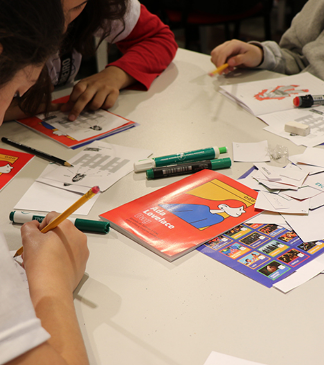 Meninas desenhando e escrevendo durante uma oficina do Ada Lovelace Day